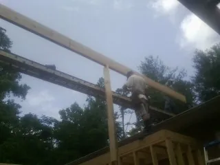 Carpenter setting a ridge beam over a new addition frame — Ice Dam Removal by Roofing Brothers in Wellford