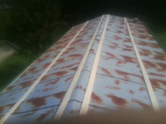Rusted metal roof panels with new wood purlins before replacement — Storm Damage Roof Repair in Wellford by Roofing Brothers